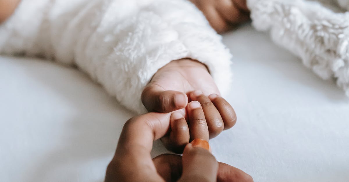 A hand holding a baby