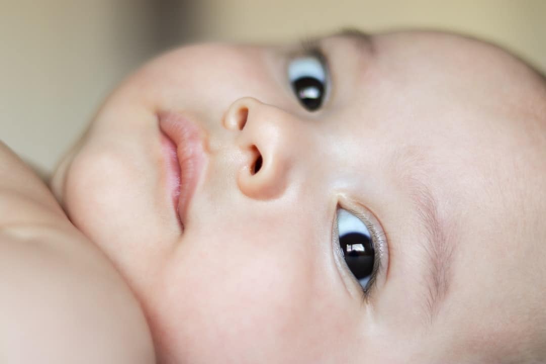 A close up of a baby with blue eyes