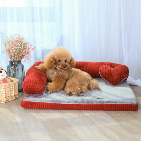 A large brown teddy bear sitting on top of a bed